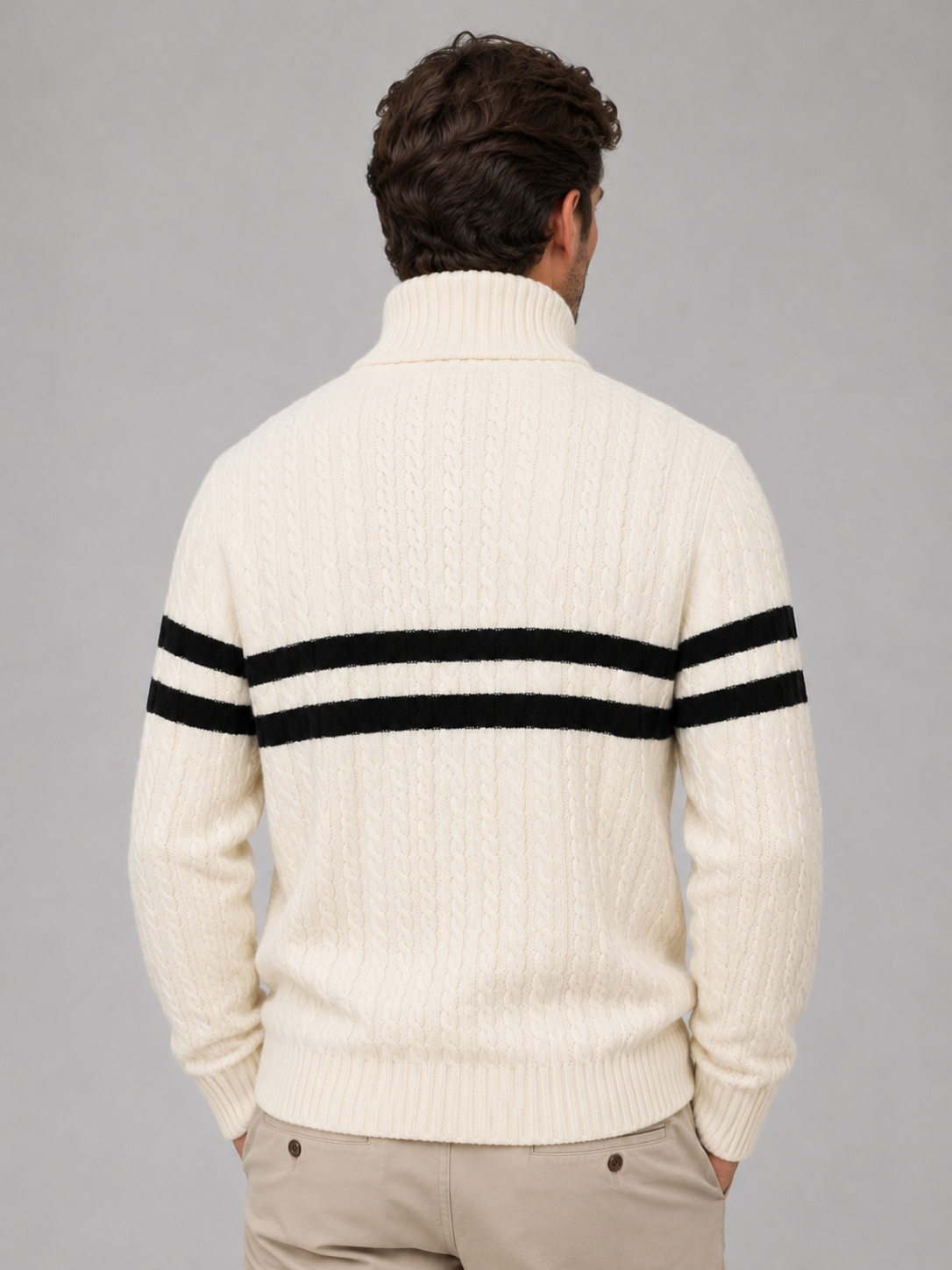 Men's cream wool cable knit sweater with black striped detail on back, turtleneck collar and half-zip, worn with beige pants