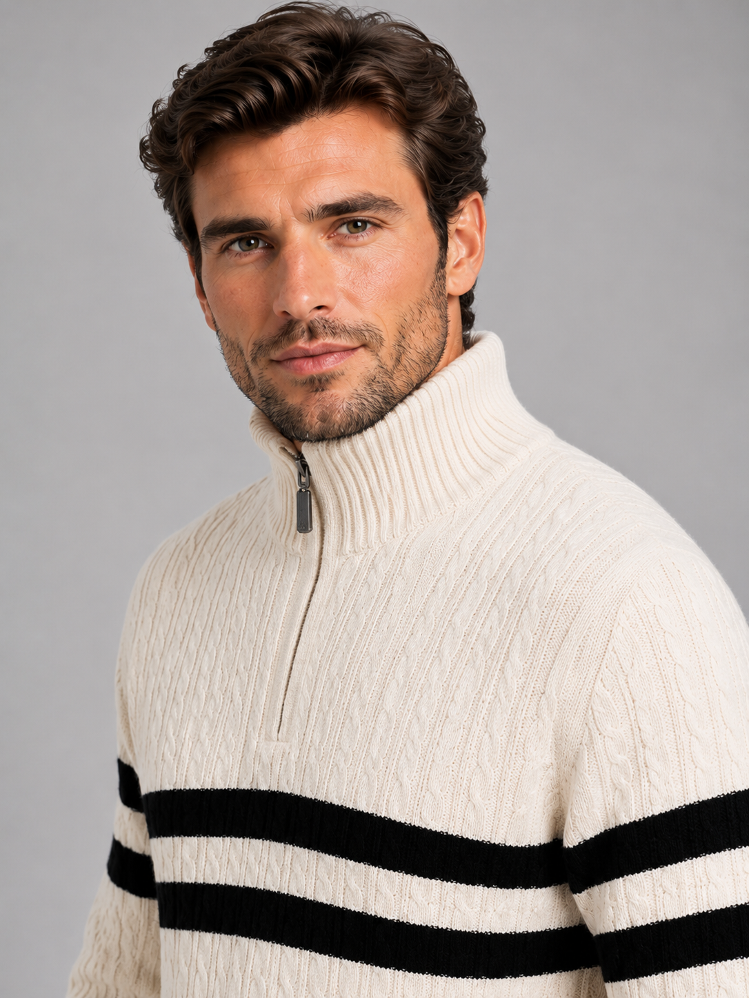 Man wearing cream and black striped high neck half-zip wool cable knit jumper against gray background