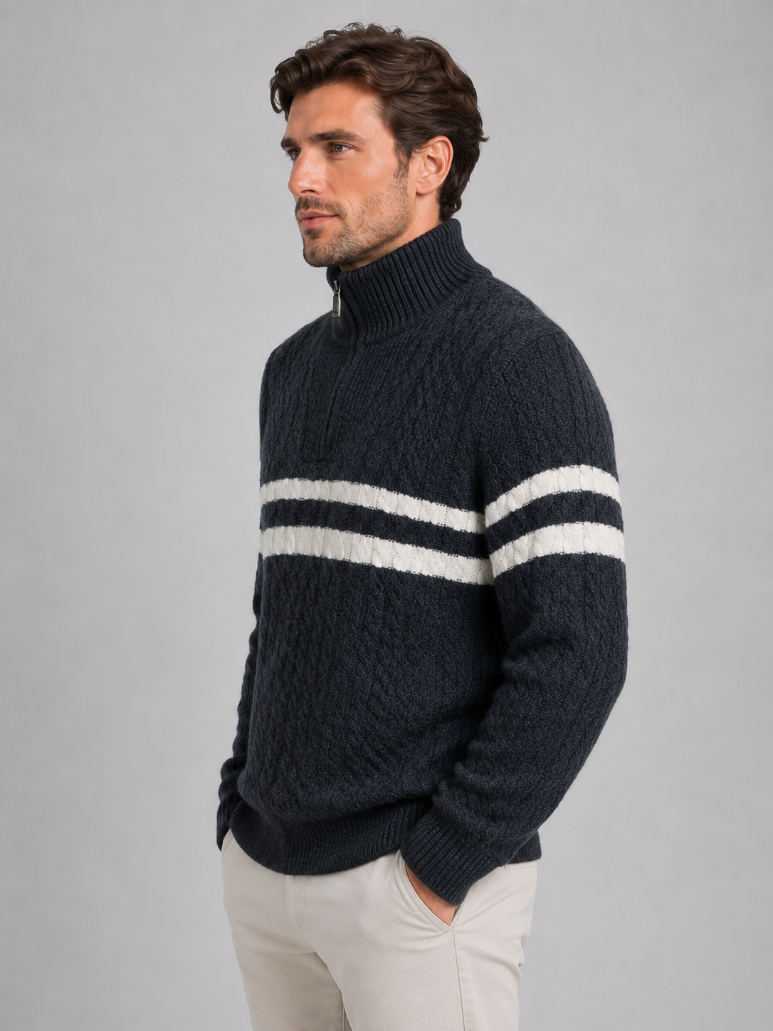 Men's black wool cable knit jumper with white stripes on chest, high neck, and half-zip, worn with cream pants