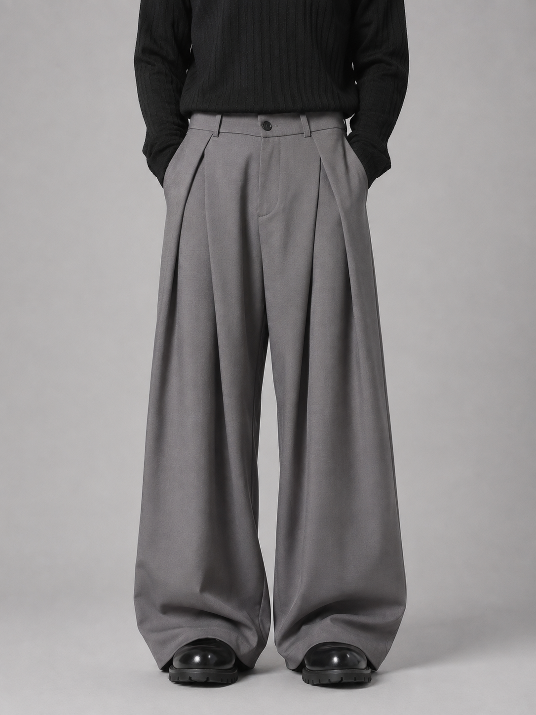 Men's gray pleated tailored baggy wide leg trousers with black shirt and black platform shoes