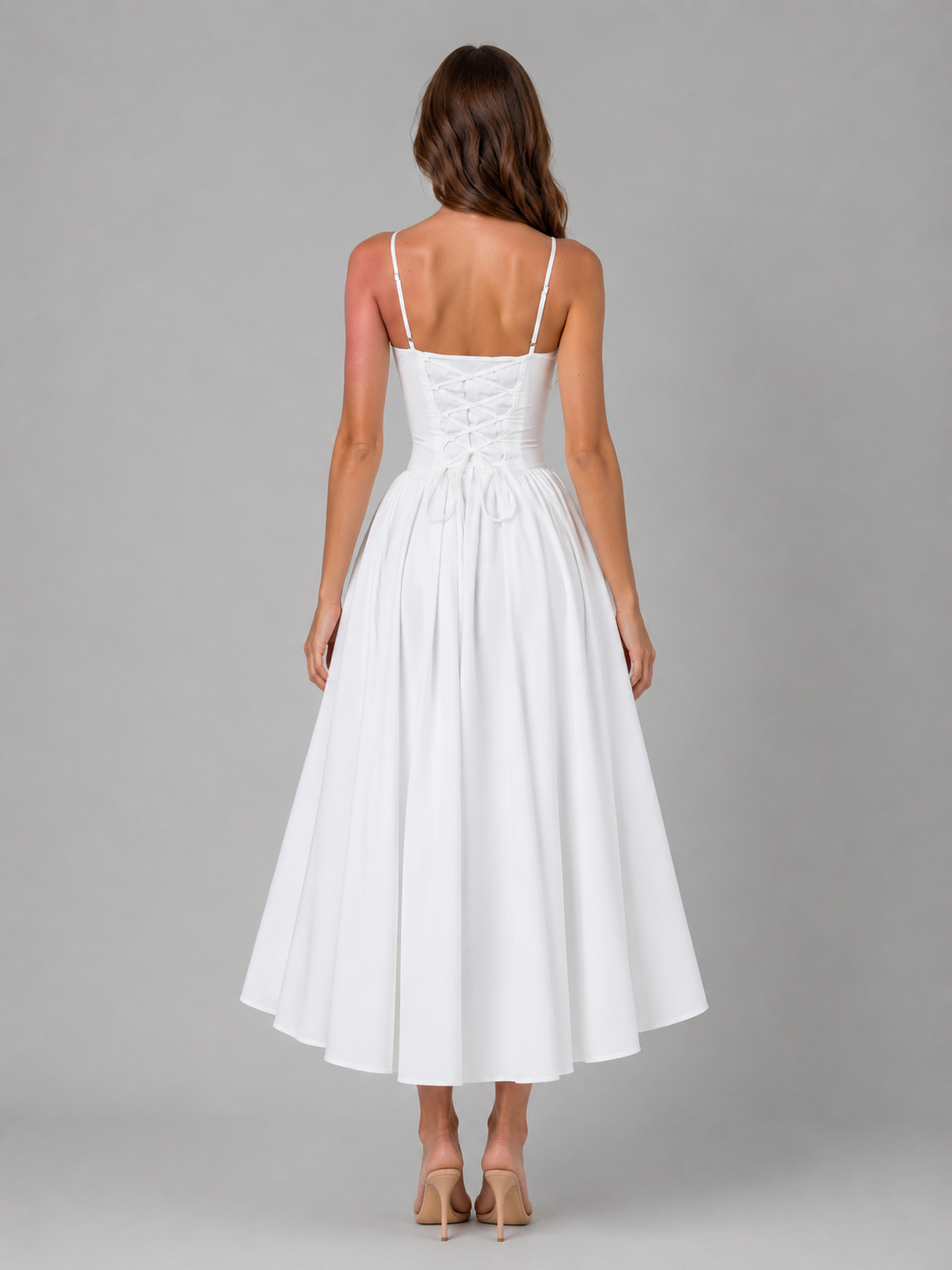 Woman wearing white sleeveless corset midi dress with lace-up back, full skirt, and tan heels, viewed from behind