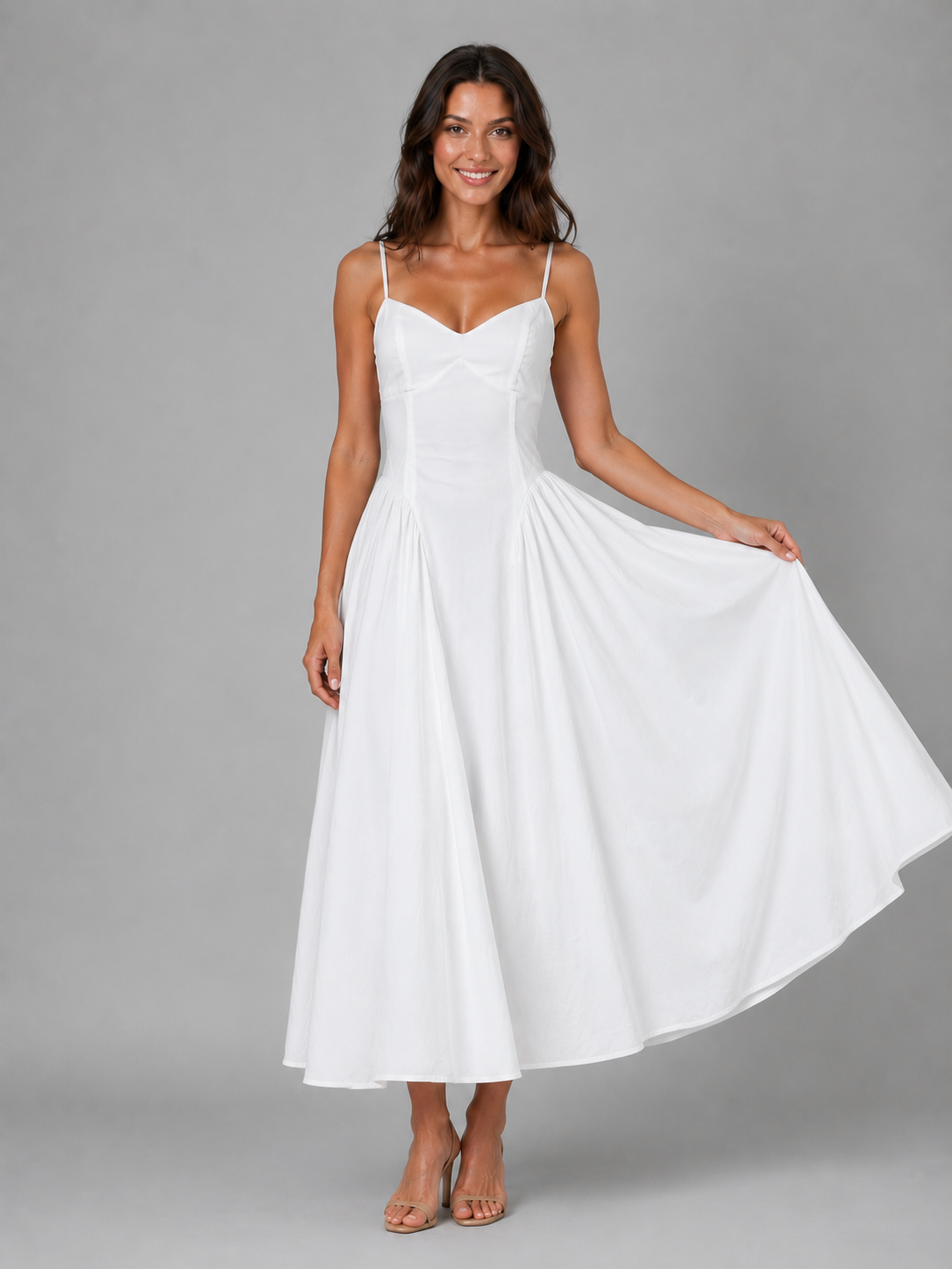 Woman wearing white sleeveless corset midi dress with full skirt and spaghetti straps, styled with tan sandals