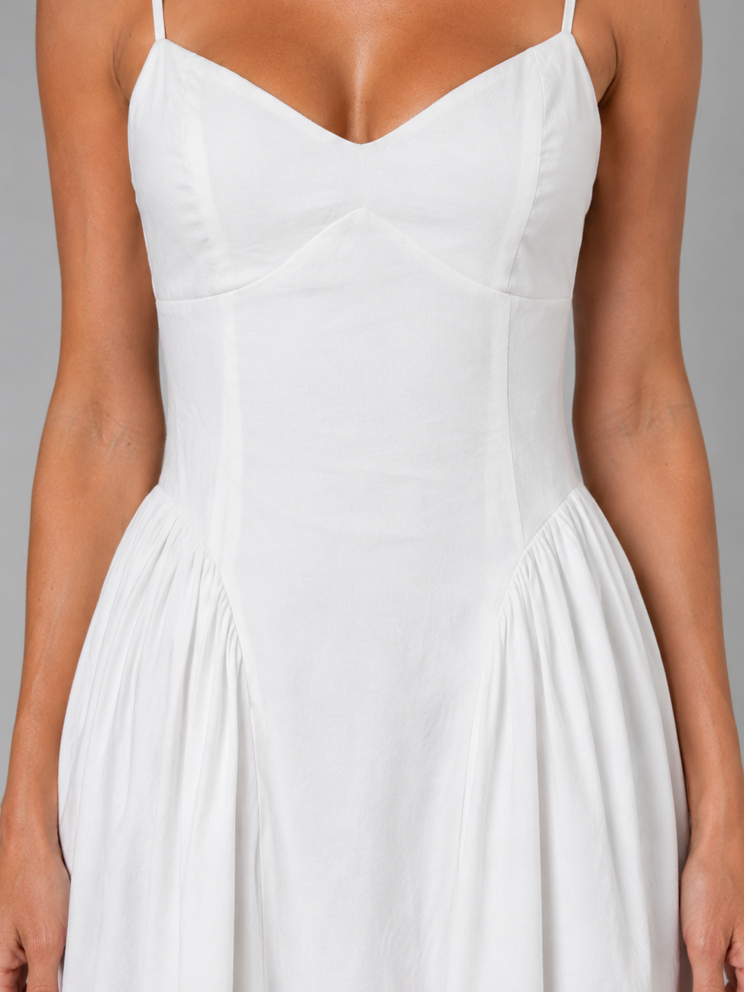 White sleeveless corset midi dress with sweetheart neckline and pleated skirt on model