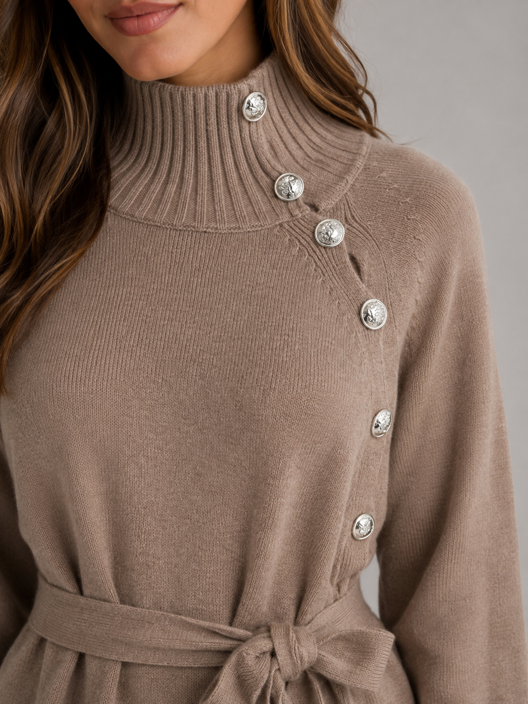 Women's beige roll neck knitted dress with decorative button details down the side and a tied waist belt