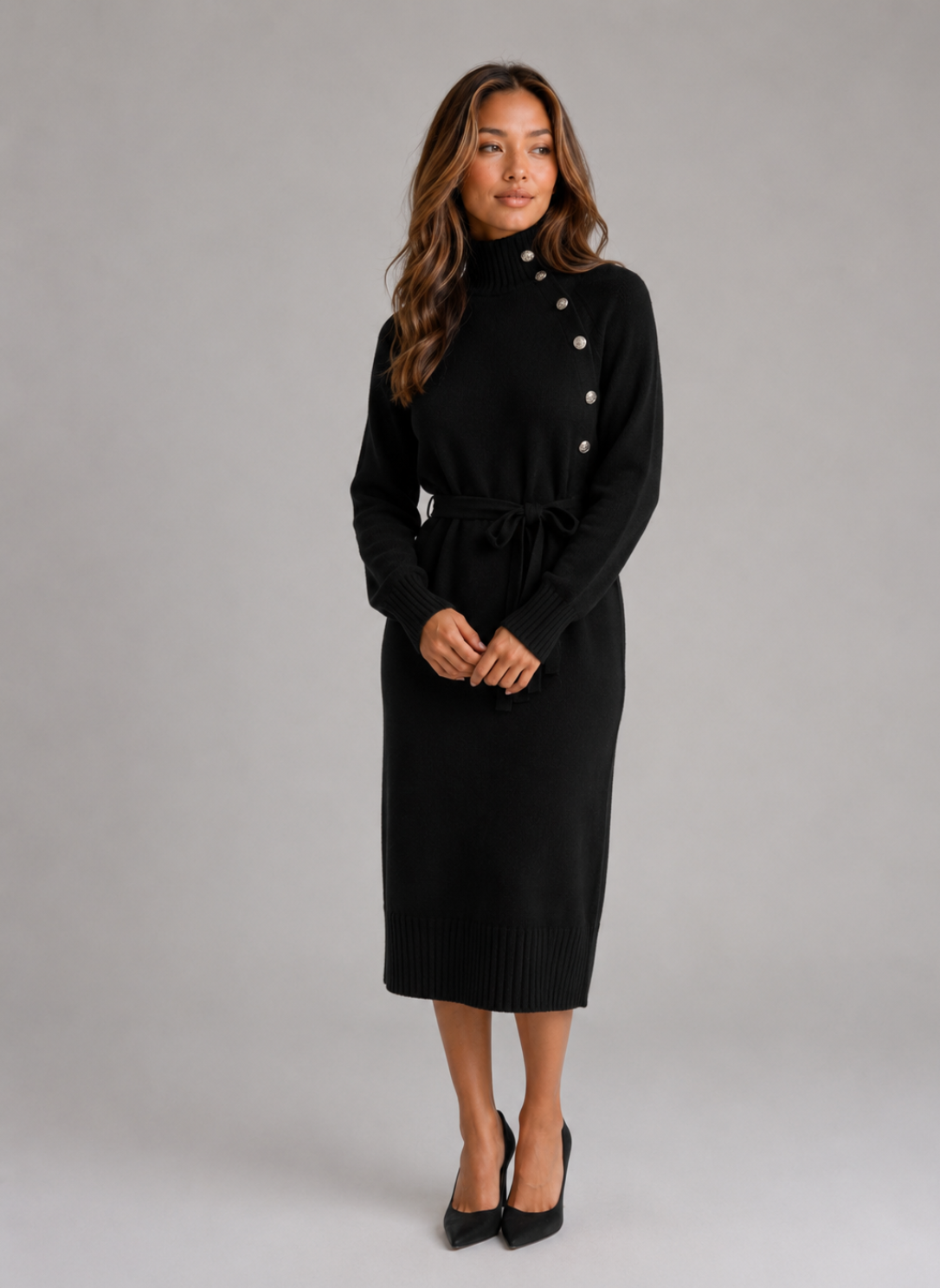 Woman wearing black roll neck belted midi knit dress with button details and long sleeves, styled with black heels