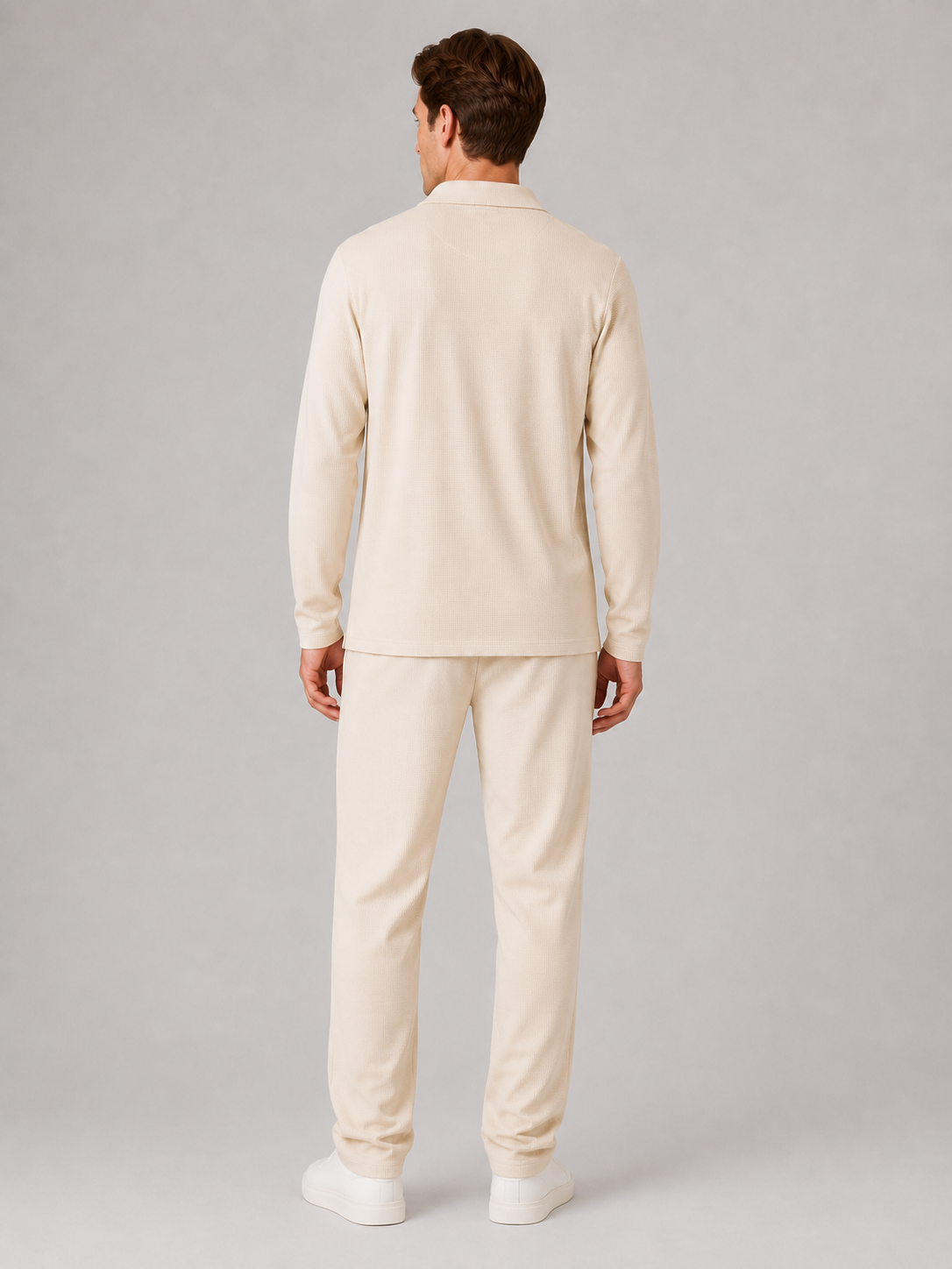 Man wearing cream textured quarter-zip polo shirt and matching smart casual trousers, viewed from behind
