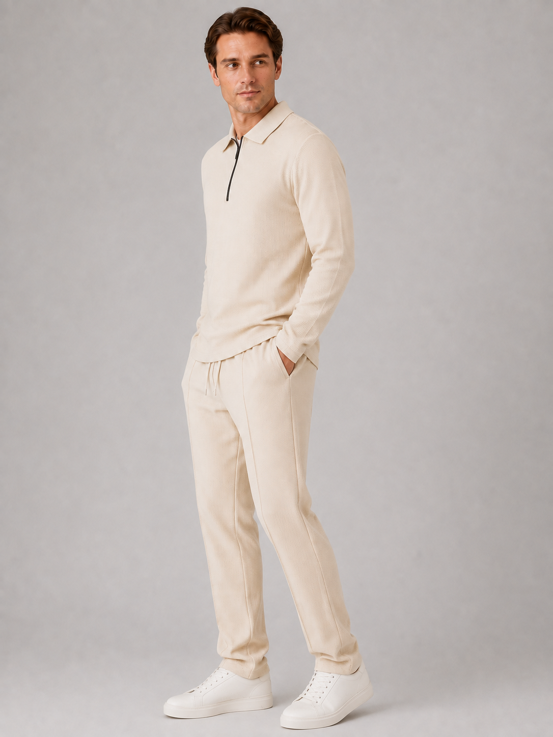 Man wearing cream textured quarter-zip polo and matching smart casual trousers with white sneakers