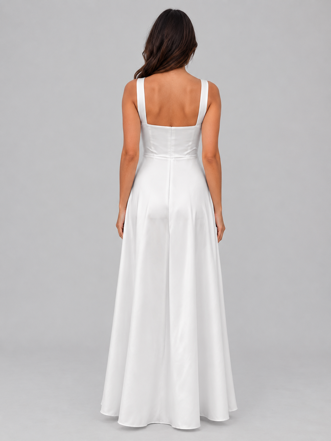 Woman wearing white A-line maxi dress with square neckline, sleeveless design, structured bodice, and open back