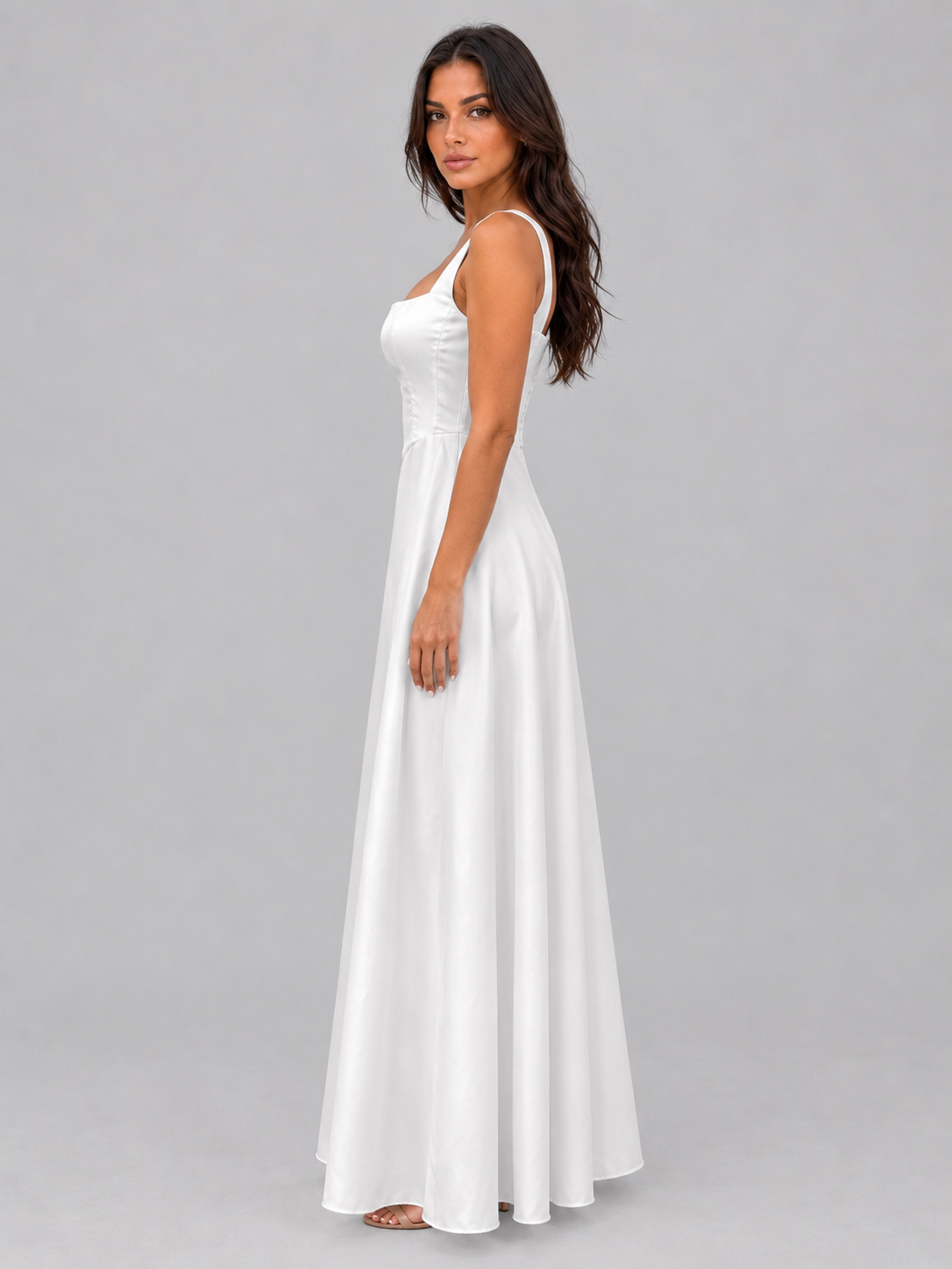 Woman wearing white sleeveless A-line maxi dress with square neckline and structured bodice, posed against gray background