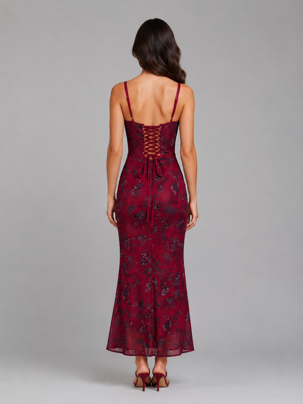 Woman wearing burgundy floral corset maxi dress with lace-up back detail and spaghetti straps, viewed from behind