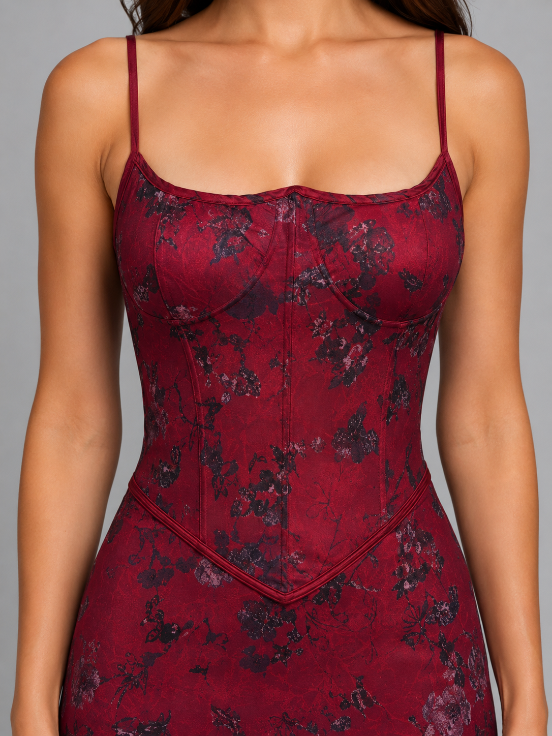 Woman wearing burgundy floral corset maxi gown dress with lace-up back and spaghetti straps