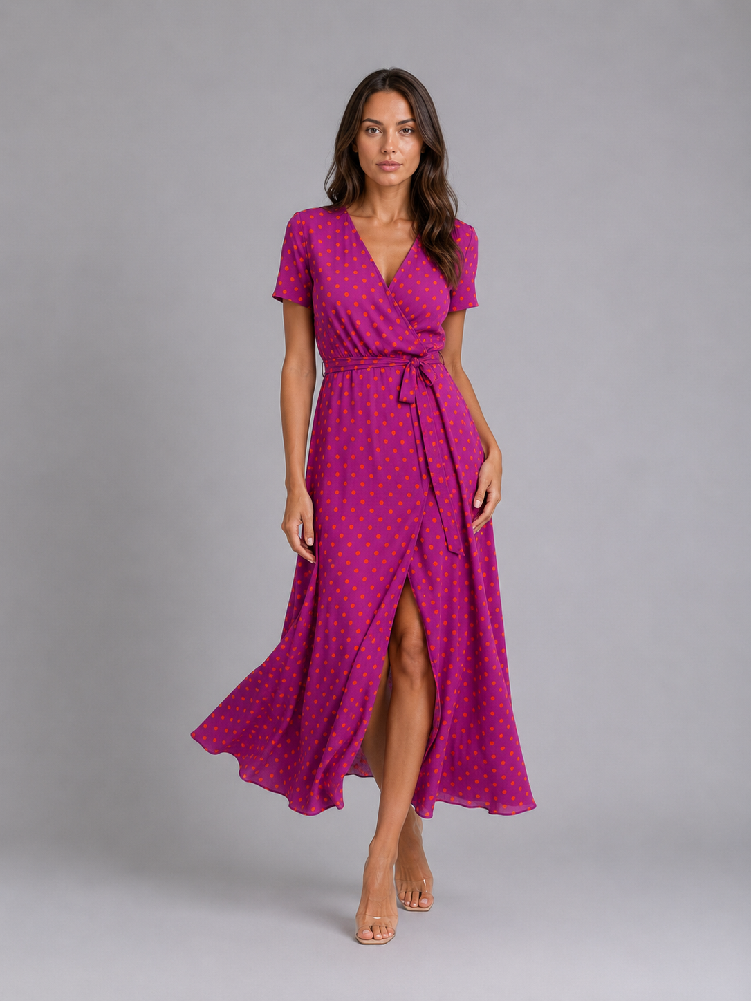Woman wearing magenta floral wrap midi dress with short sleeves, tie waist, and thigh-high slit, styled with nude sandals
