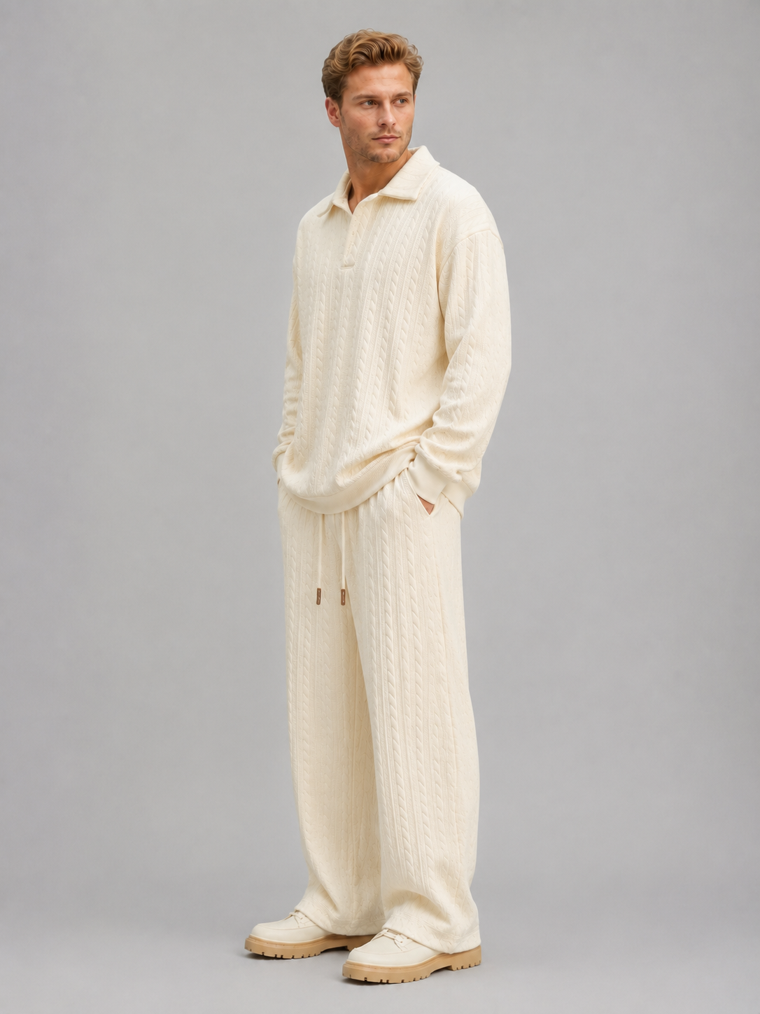 Man wearing cream cable knit collared shirt and matching wide-leg trousers with drawstring waist, styled as two-piece set with tan boots