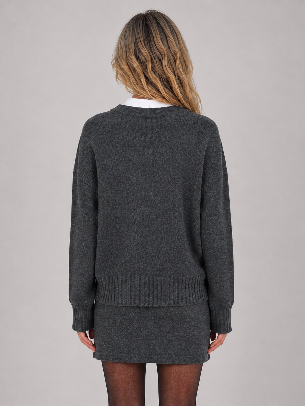 Woman wearing dark gray knitted jumper and mini skirt two-piece set, white collar, back view