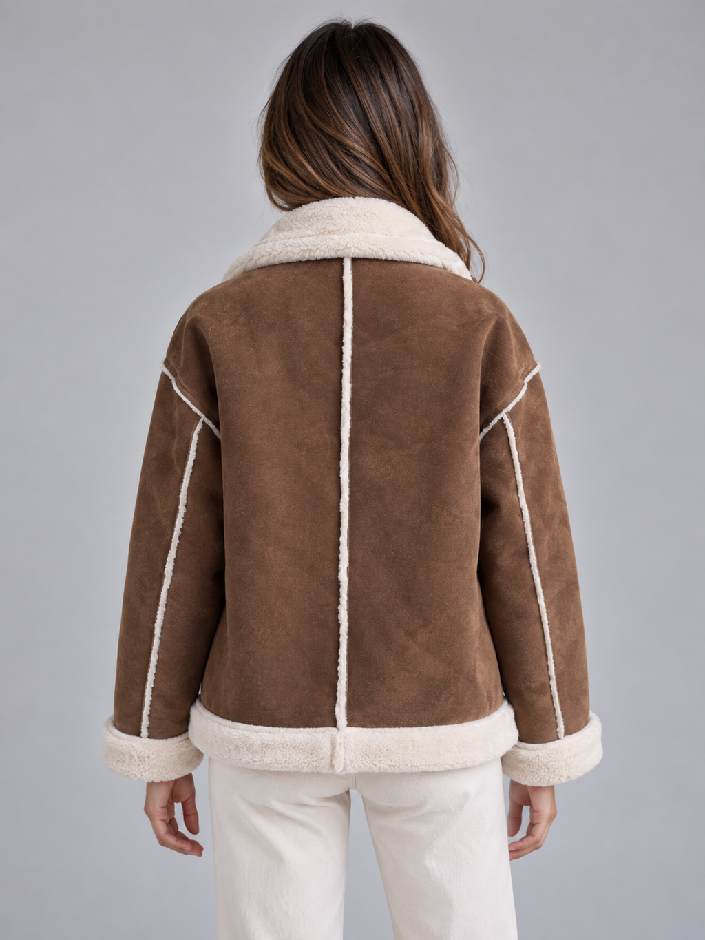 Woman wearing brown suede aviator jacket with cream shearling collar and cuffs, back view