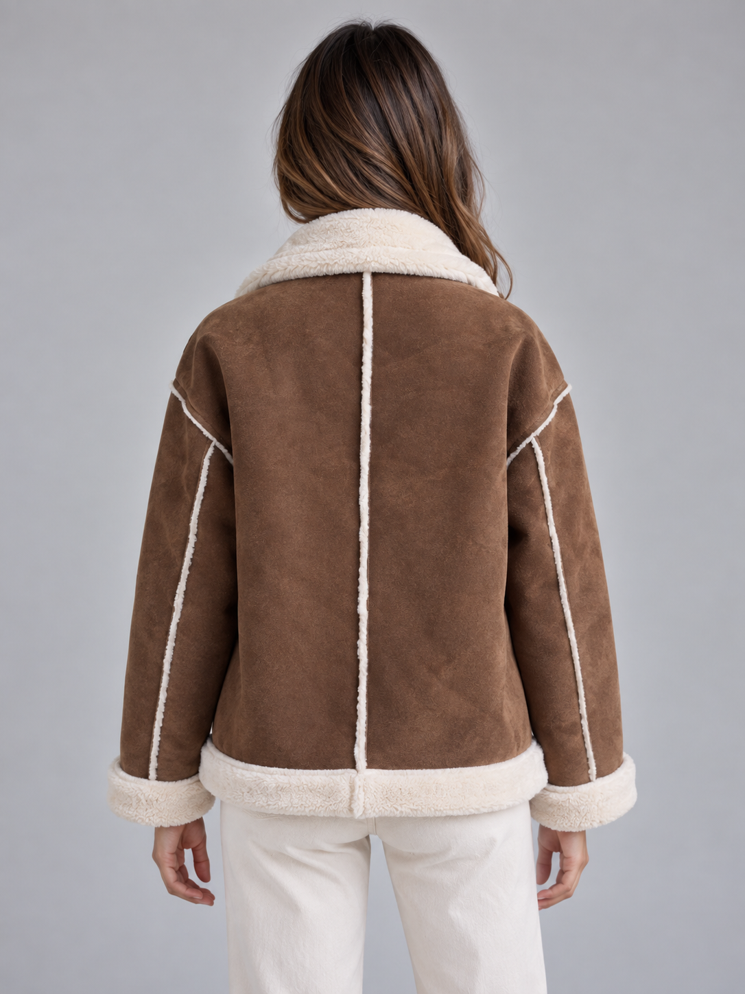 Woman wearing brown suede aviator jacket with cream shearling collar and cuffs, back view