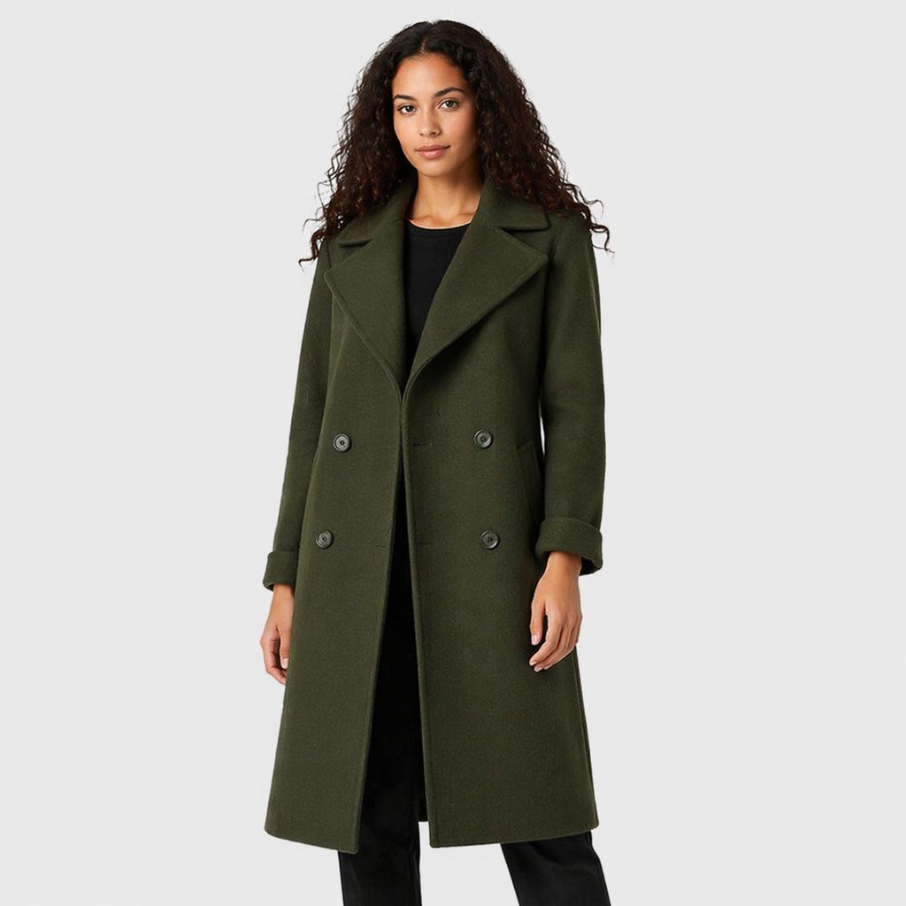 Woman wearing olive green double-breasted trench coat with belt over black top and pants