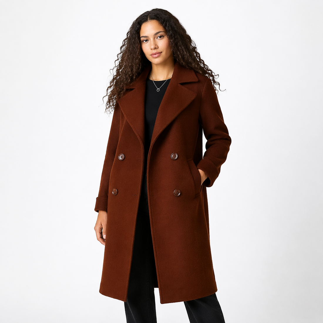 Woman wearing brown double-breasted trench coat over black top with notch lapels and belt detail