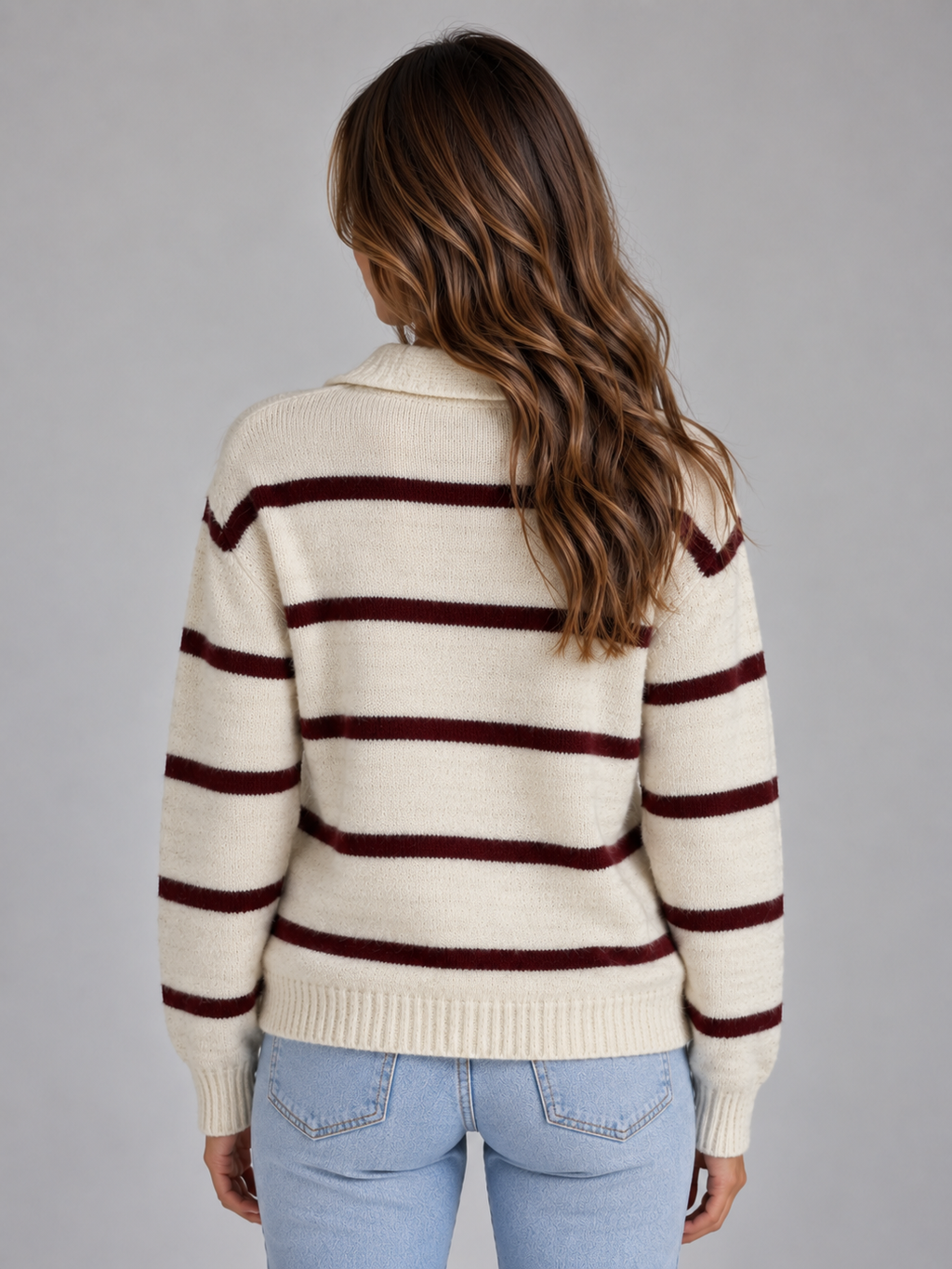Woman wearing cream and burgundy striped collared v-neck wool knit sweater with light blue jeans, back view