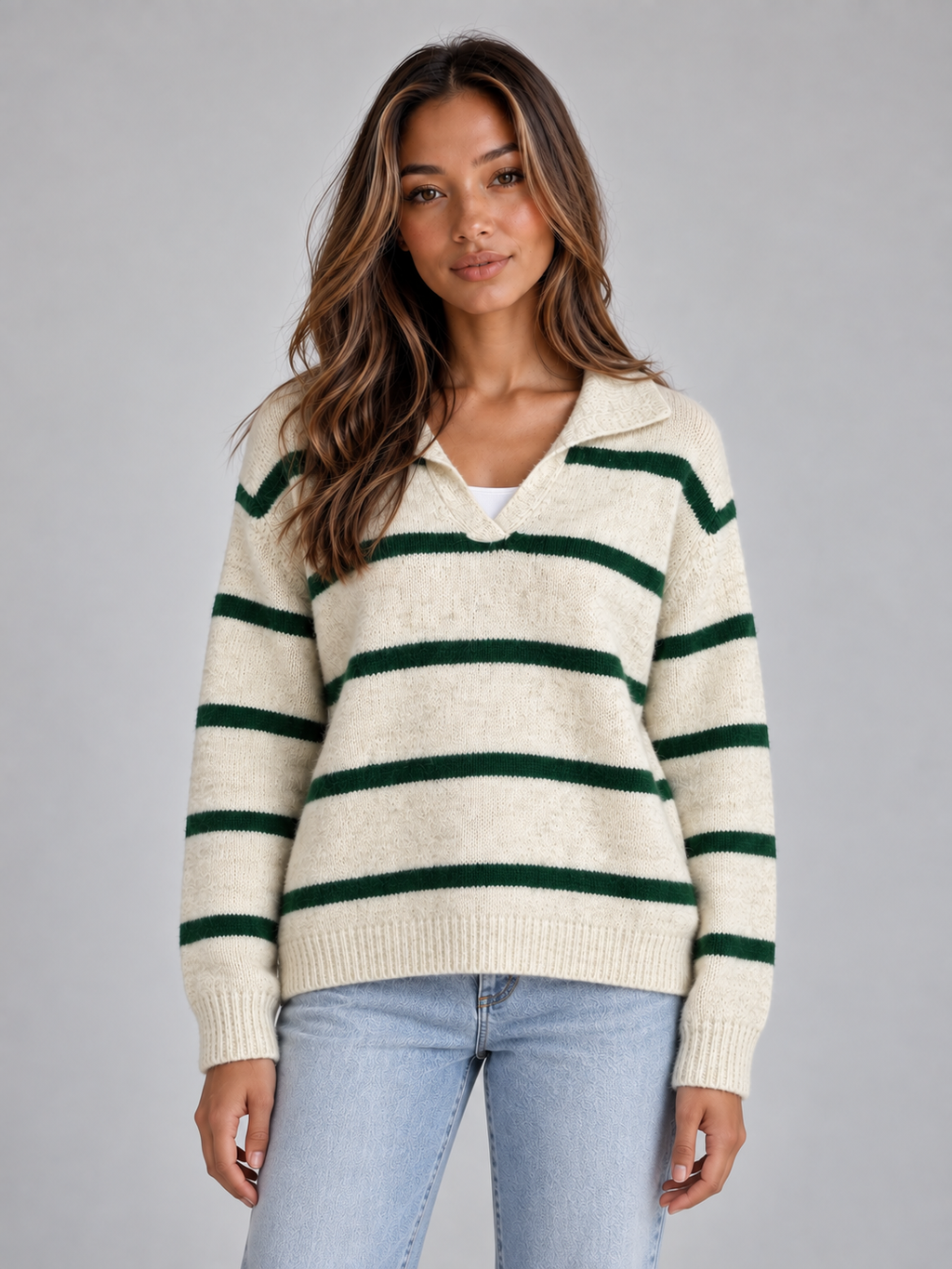 Woman wearing cream and green striped wool collared v-neck sweater with long sleeves over light blue jeans