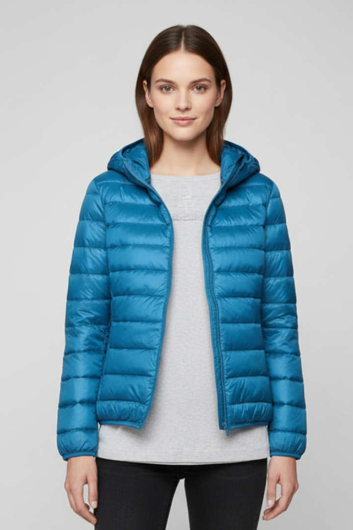 Woman wearing teal quilted hooded zip jacket over white shirt and black pants