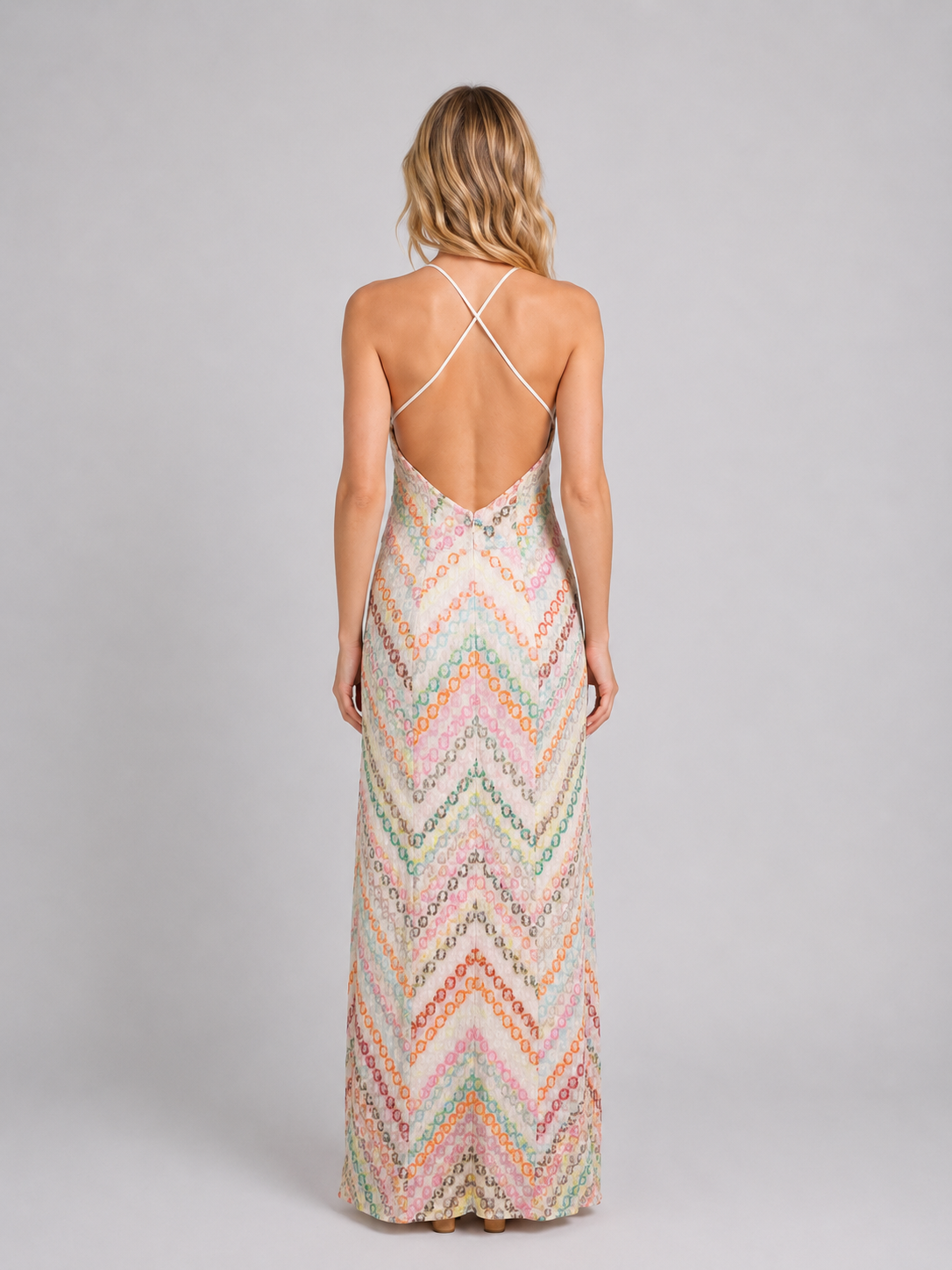 Woman wearing multicolor boho crochet knit maxi dress with chevron pattern and criss-cross strappy back