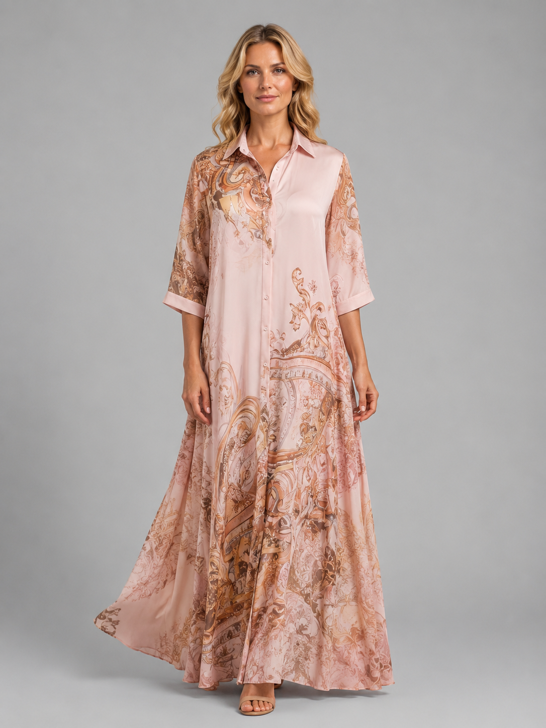Woman wearing a pink and tan paisley printed button front maxi dress with three-quarter sleeves and flowing A-line silhouette