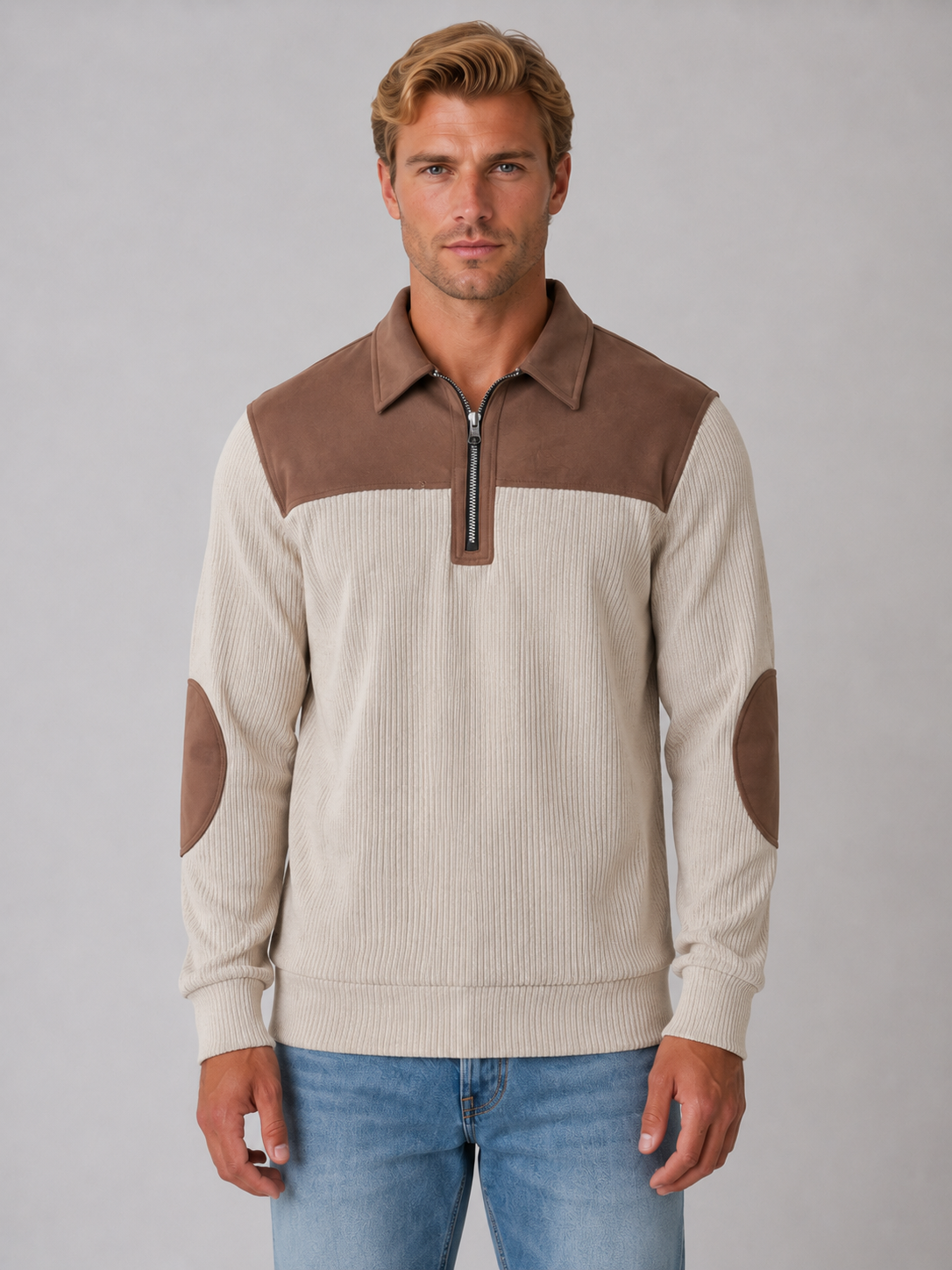 Men's ribbed cream pullover quarter zip jumper with brown color block yoke and elbow patches, worn with blue jeans