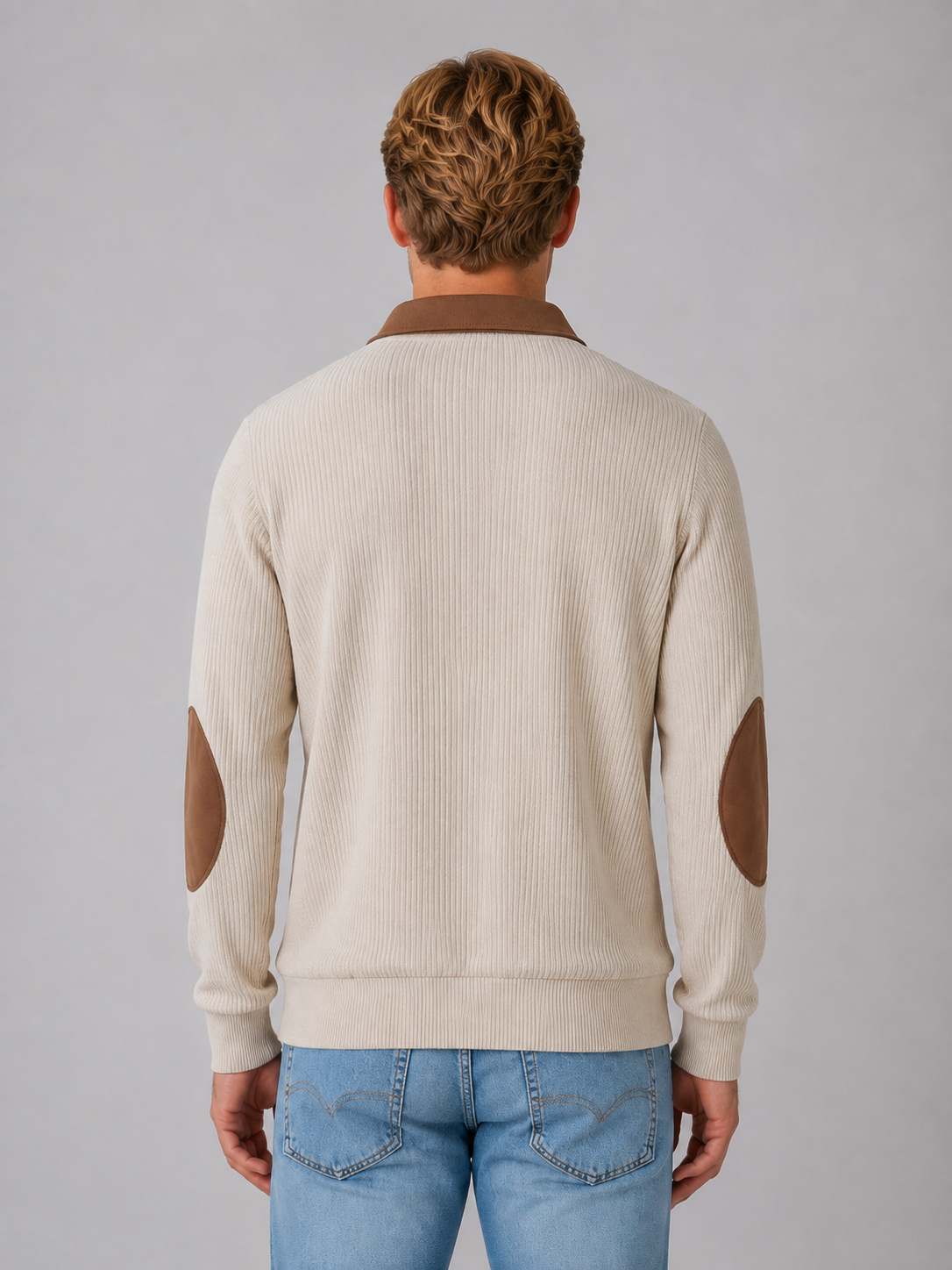 Man wearing cream ribbed pullover quarter zip jumper with brown collar and elbow patches, styled with blue jeans
