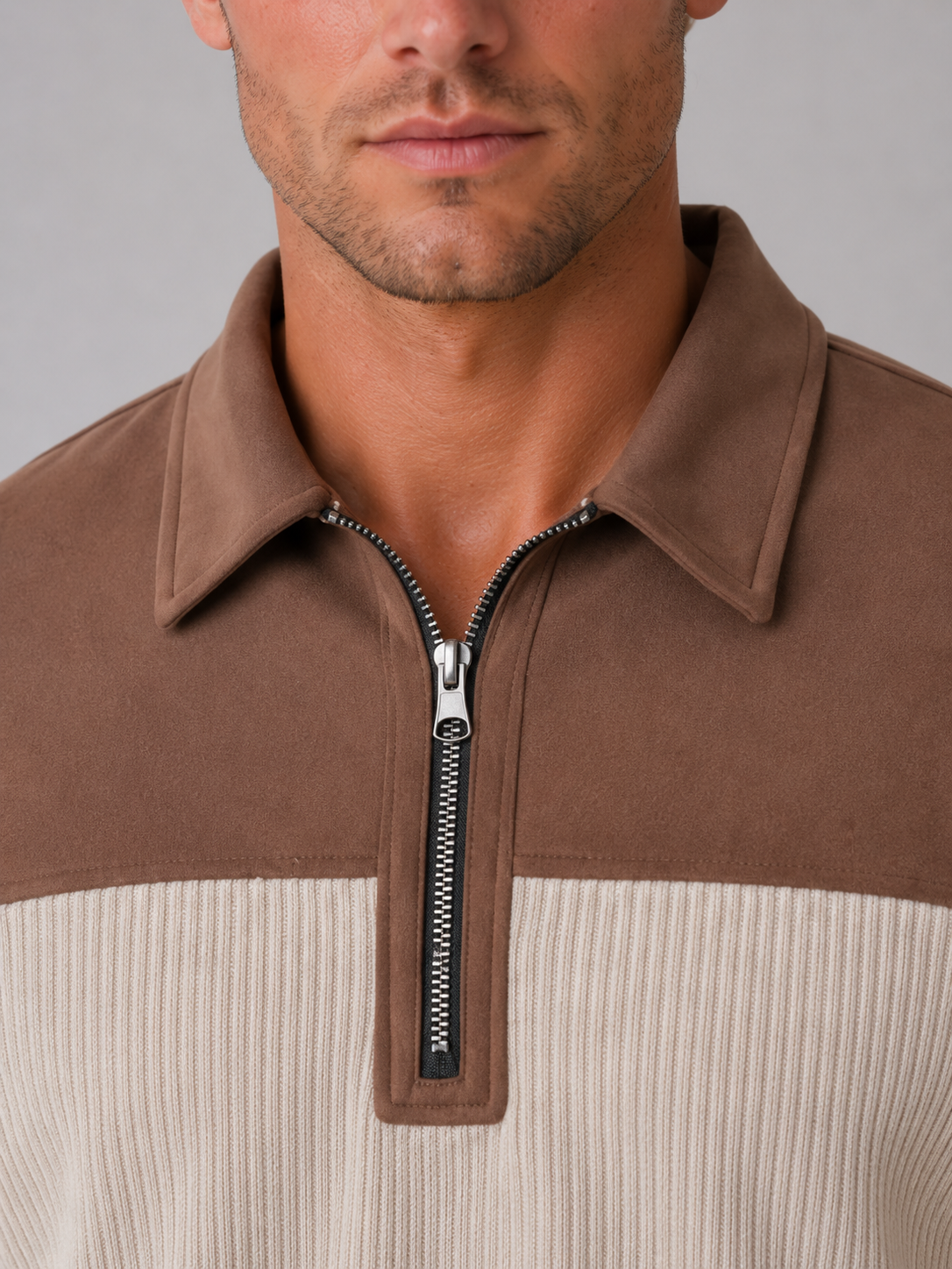 Man wearing brown and cream ribbed long sleeve quarter zip pullover with elbow patches and collared neckline