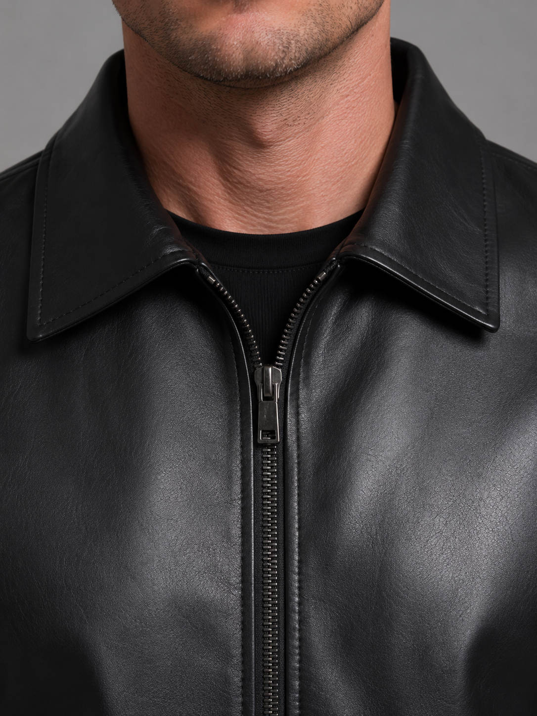 Man wearing black leather jacket with spread collar and front zip closure
