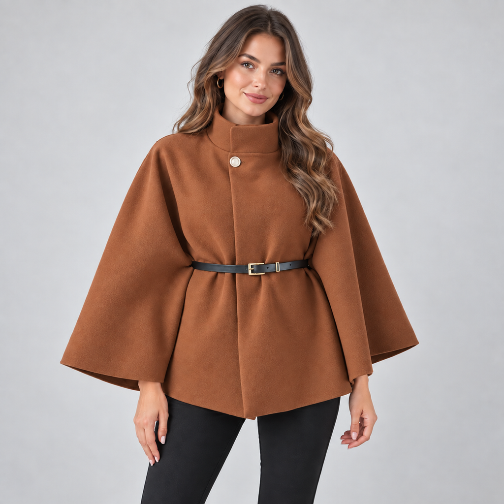 Woman wearing brown high neck belted cape coat with long sleeves over black pants, styled with hoop earrings