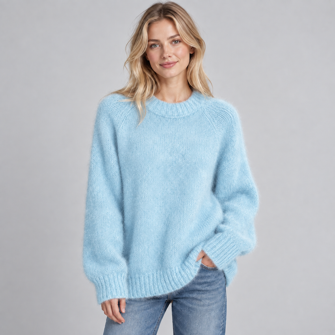 Woman wearing light blue fluffy knit round neck jumper with ribbed cuffs and hem, paired with blue jeans