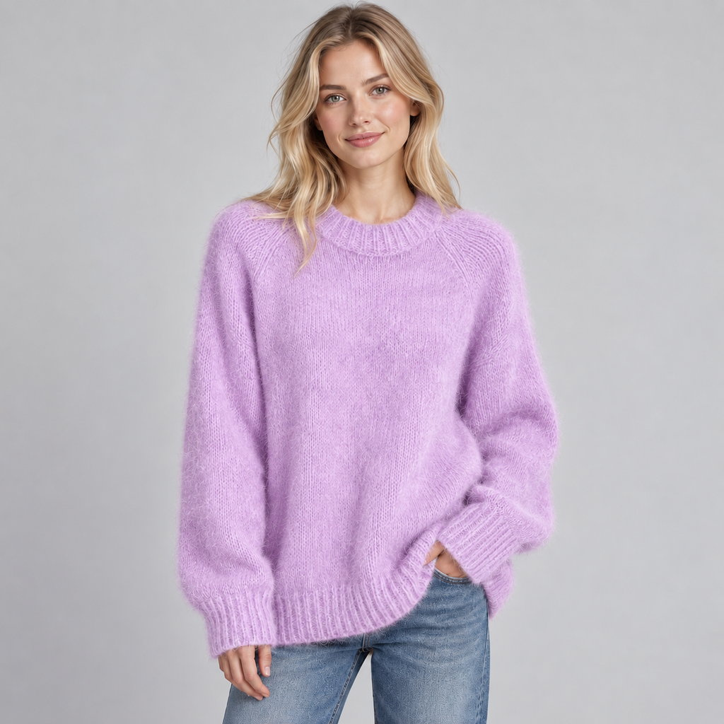 Woman wearing lavender fluffy knit crewneck sweater with ribbed cuffs and hem, paired with blue jeans