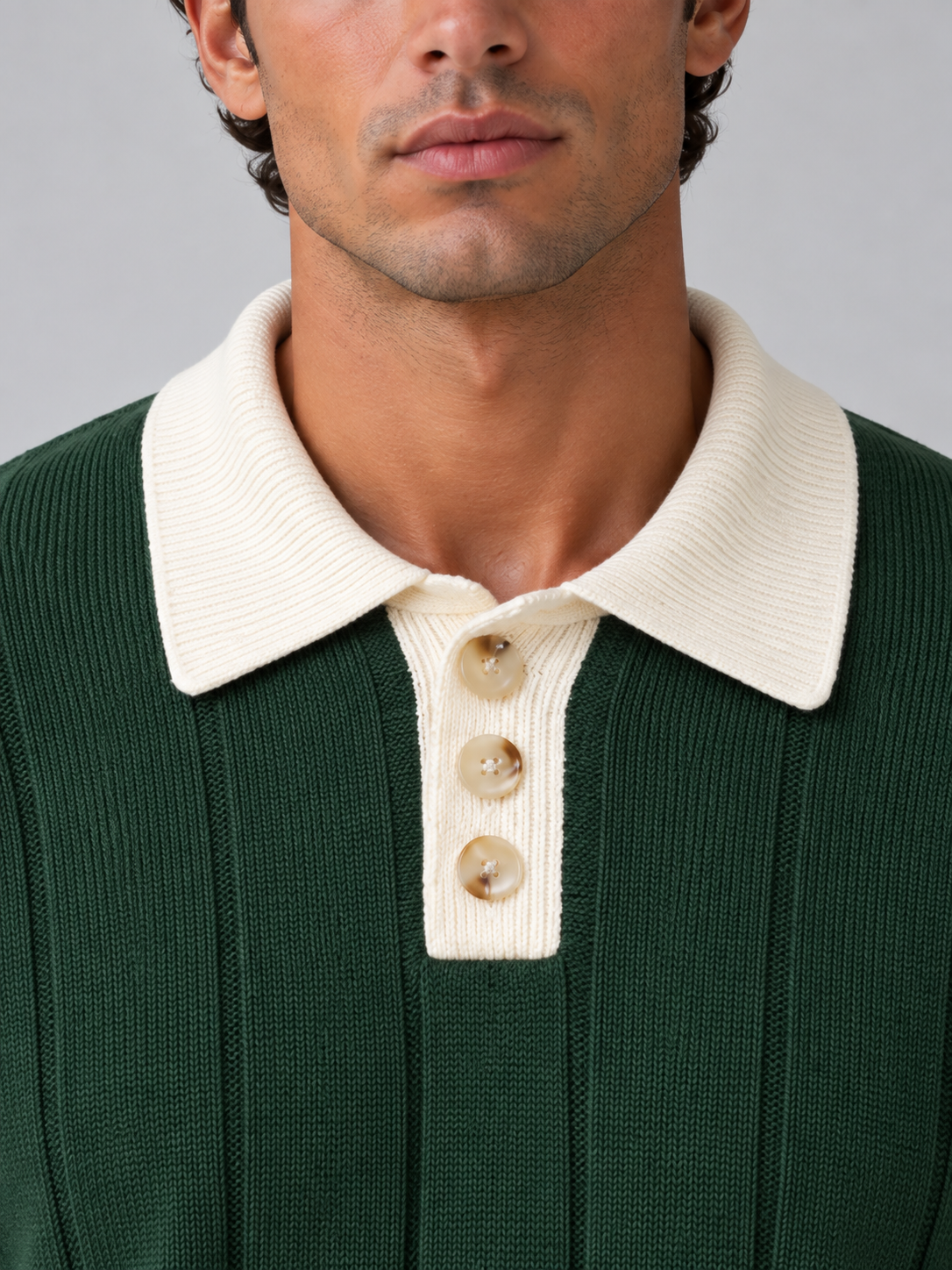 Man wearing green ribbed knit polo jumper with cream contrast collar and button neck detail