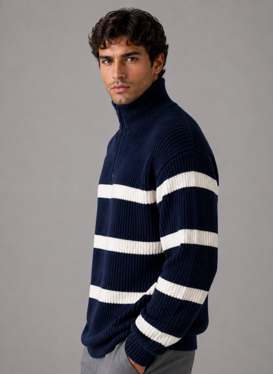 Men's oversized navy and white striped ribbed half zip knit pullover with turtleneck, modeled on gray background