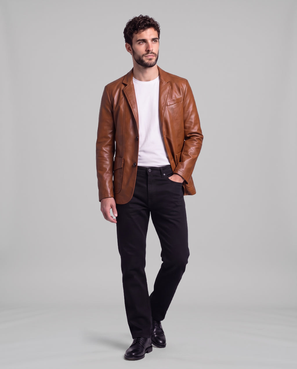 Male model wearing the Soren leather blazer in Cognac Brown with black jeans, full-length view