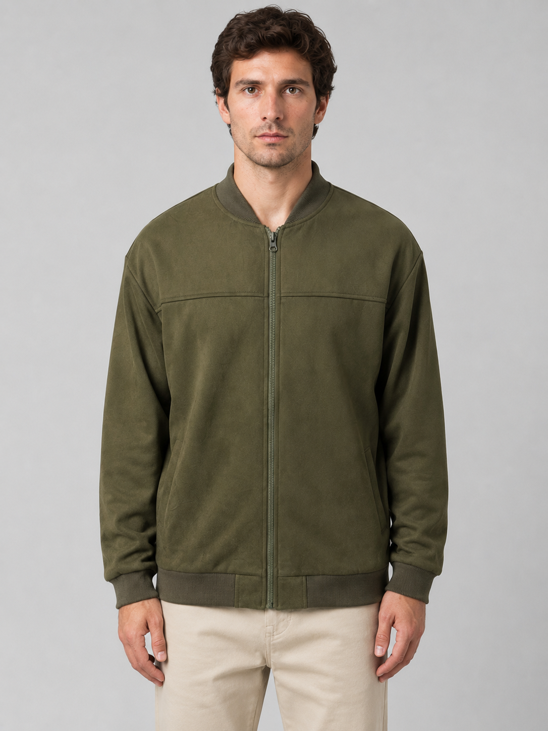 Man wearing olive green regular fit zip-up bomber jacket with ribbed collar and cuffs, paired with cream pants