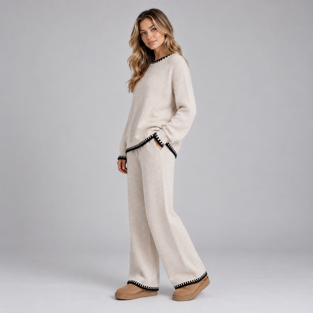 Woman wearing cream knitted wide leg lounge set with black contrast trim at neckline, cuffs and hem, paired with tan slippers