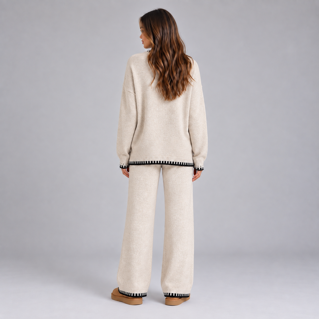 Woman wearing cream knitted sweater and wide leg lounge pants with black and white striped contrast trim, viewed from behind
