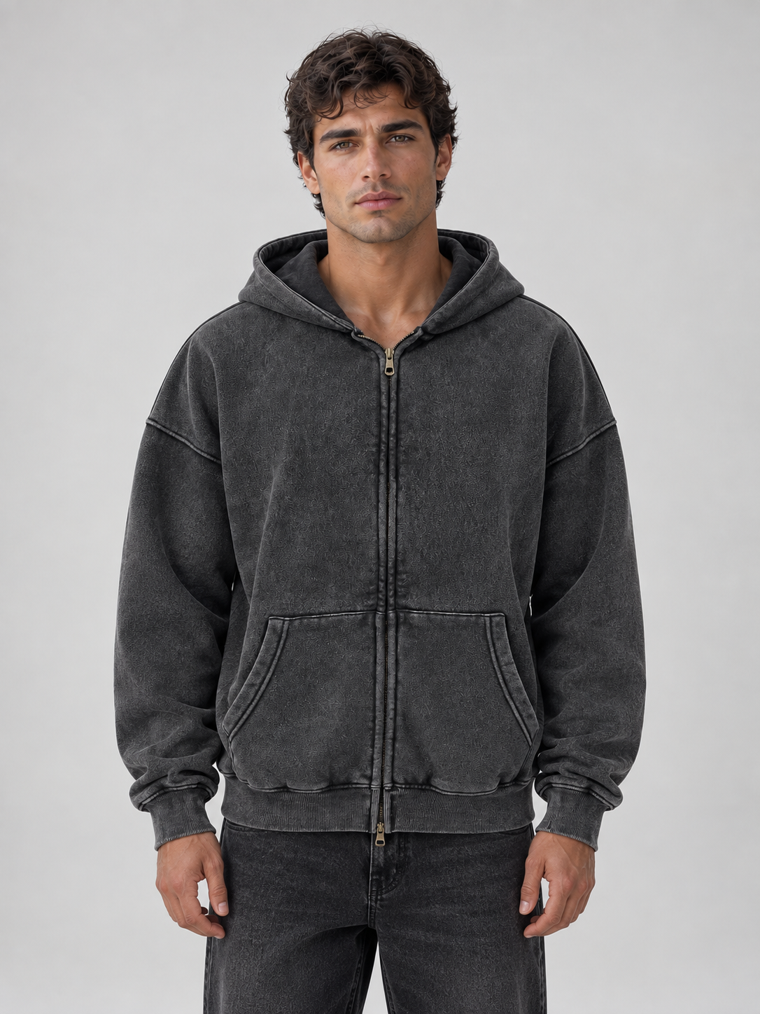 Man wearing charcoal washed oversized full zip hooded jacket with kangaroo pockets over dark jeans