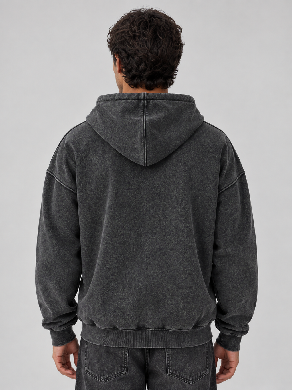 Man wearing charcoal washed full zip oversized hooded jacket with ribbed cuffs and hem, shown from back view