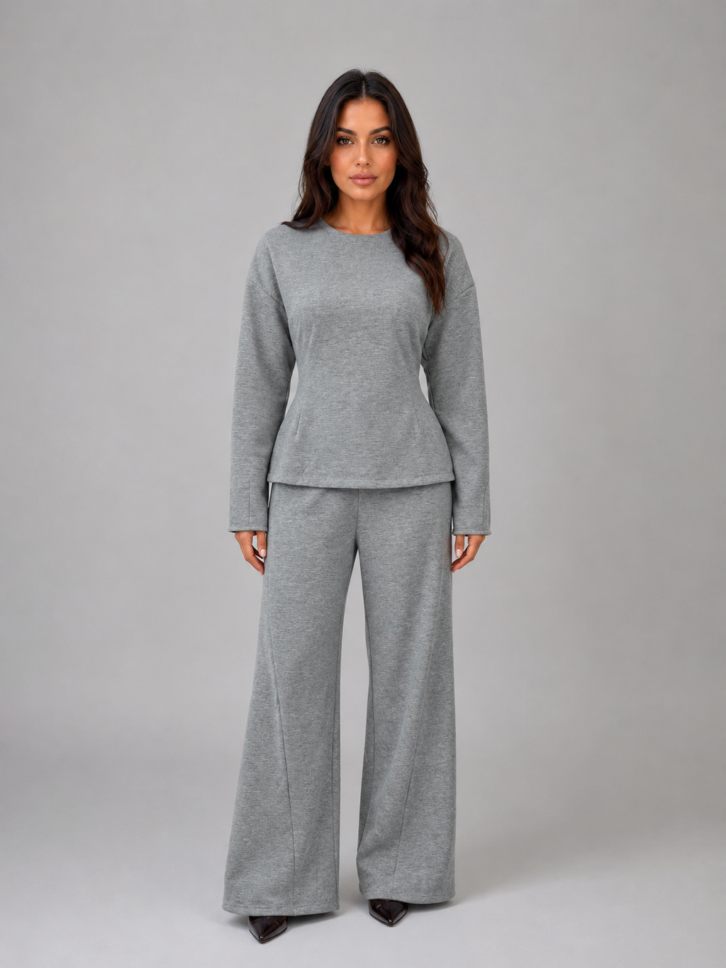 Woman wearing gray long-sleeve fitted top and matching wide-leg lounge pants on white background
