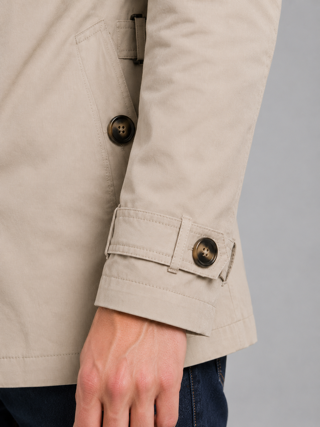 Men's beige classic belted double breasted overcoat sleeve detail showing dark buttons and adjustable cuff strap