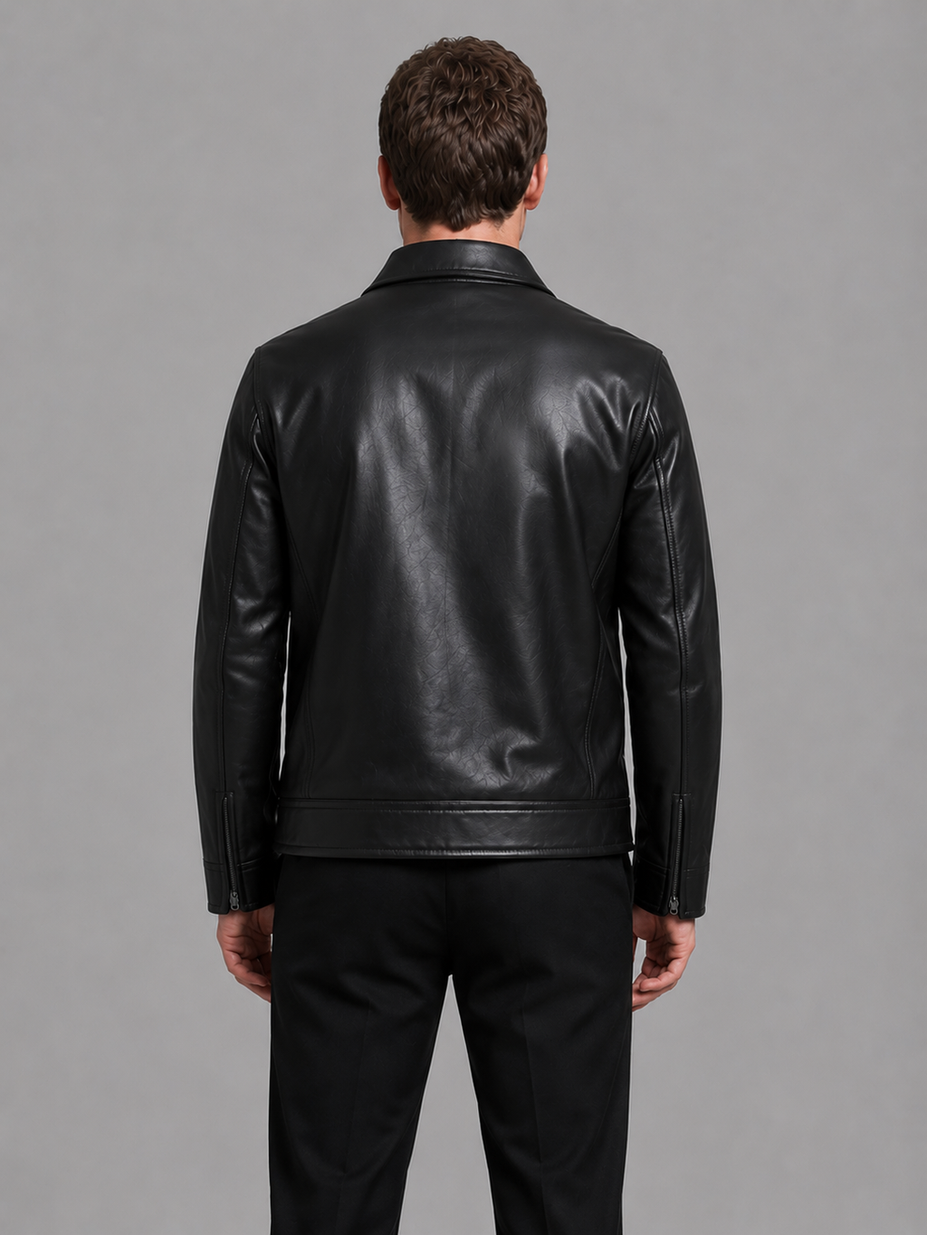Man wearing black leather jacket with zip pockets and collar, shown from back view against gray background