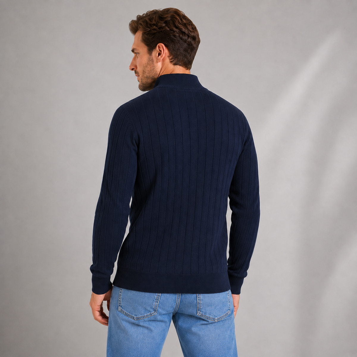 Man wearing navy ribbed funnel neck quarter zip jumper with blue jeans, shown from back view against neutral background