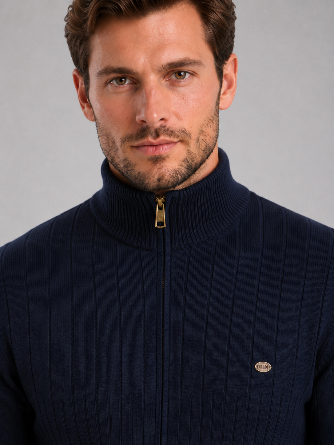 Man wearing navy ribbed funnel neck quarter zip jumper with gold zipper and brand logo on chest