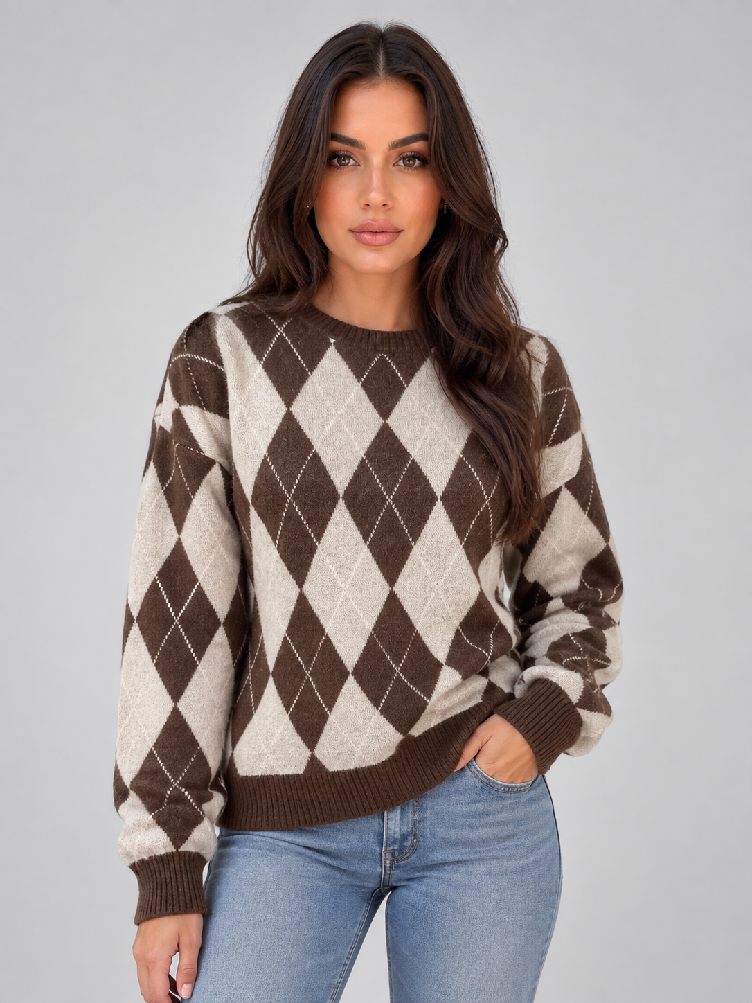 Woman wearing brown and cream argyle knit sweater with crew neck and long sleeves, paired with blue jeans