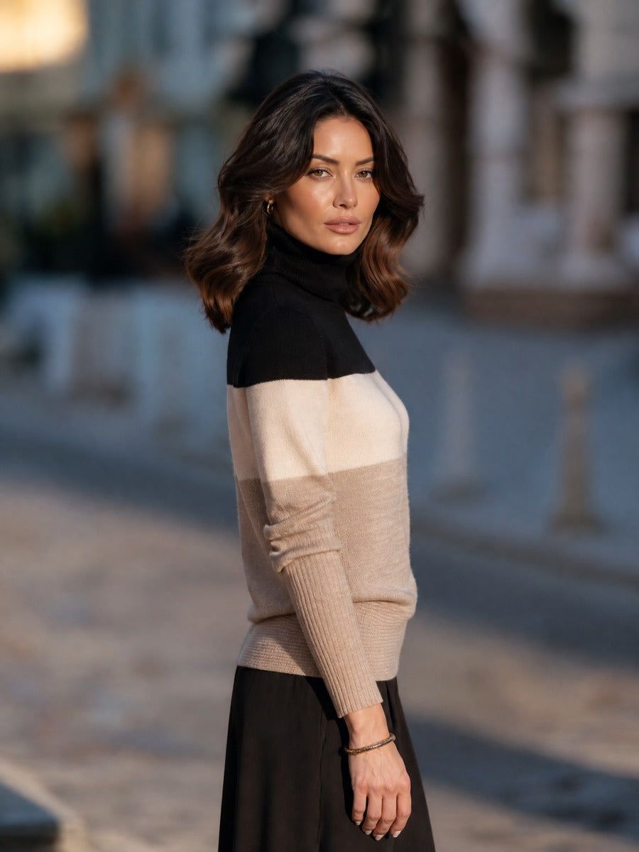 Woman wearing black and cream colorblock ribbed knit turtleneck sweater with black skirt, standing outdoors