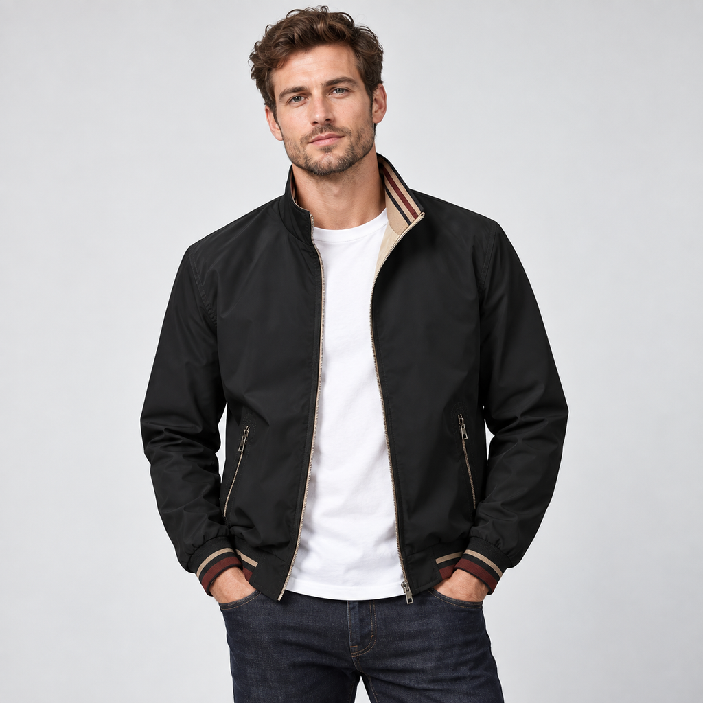 Man wearing black reversible zip-up bomber jacket with tan lining over white t-shirt and dark jeans